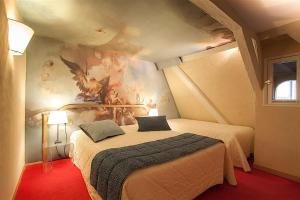 
a bedroom with a bed and a painting on the wall at Hotel Cathédrale in Strasbourg
