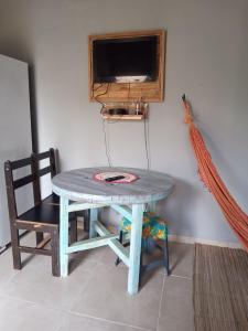 a table and a chair in a room with a tv at Cantinho do sossego edícula Massaguaçu in Massaguassu