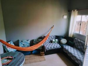 a couch with a hammock in a living room at Cantinho do sossego edícula Massaguaçu in Massaguassu