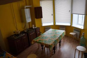 a kitchen with a table and a sink and windows at Holiday home Sportivnaya in Kazan