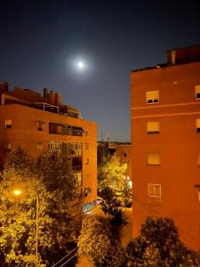 a view of a building at night with the moon at Piso con Vistas y Mucho Encanto in Madrid