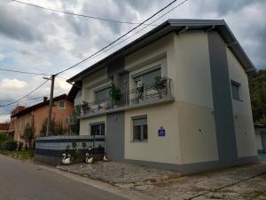 a white house with a balcony on a street at Jasmir in Bihać