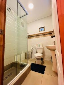 a bathroom with a glass shower and a toilet at Cabañitas Remanso del Espíritu in Isla de Maipo +50 photos