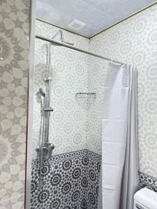 una ducha con puerta de cristal en un baño en Islam guest house, en Samarkand 10 fotos más
