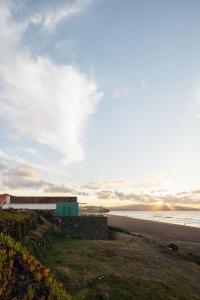 リベイラ・グランデにあるMoinho da Areiaの海を背景にした海辺の建物