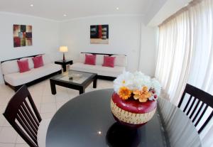 a living room with a vase with flowers on a table at Parque Mourabel, Oásis Village & Pé do Lago in Vilamoura