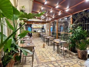 a restaurant with tables and chairs and plants at Arial Lofts in Vlorë