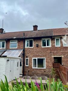 a brick house with a solar panel on it at The Olive House - 4 Bedroom, Sleeps 8, Contractors Welcome in Middlesbrough