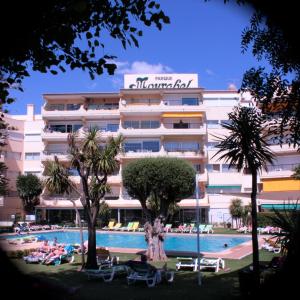 un hôtel avec une piscine en face d'un bâtiment dans l'établissement Parque Mourabel, Oásis Village & Pé do Lago, à Vilamoura