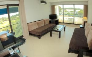 a living room with a couch and a tv at Parque Mourabel, Oásis Village & Pé do Lago in Vilamoura
