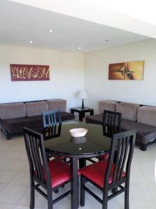a dining room with a table and chairs and a couch at Parque Mourabel, Oásis Village & Pé do Lago in Vilamoura