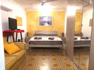 a bedroom with a bed and a couch and a television at Casa del Centro 2P in Santa Caterina Villarmosa