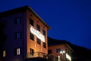 a building with a sign on it at night at Hotel Garni Cristallo in Ponte di Legno