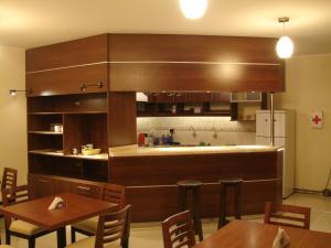 a kitchen with wooden cabinets and tables in a restaurant at Hostal Qoyllurwasi in Arequipa