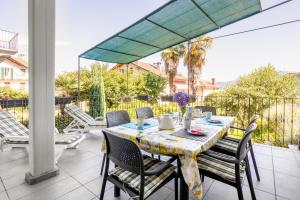 a table and chairs on a patio with an umbrella at Appartamento Gino in Cannero Riviera
