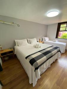 a bedroom with two beds and a window at Vista da Montanha in Petrópolis