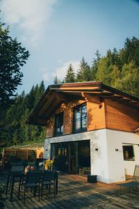 ein Haus mit einem Tisch und Stühlen davor in der Unterkunft Chalet Astra, Whirlpool & Sauna in St. Pankraz