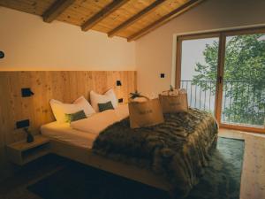 ein Schlafzimmer mit einem Bett und einem großen Fenster in der Unterkunft Chalet Astra, Whirlpool & Sauna in St. Pankraz