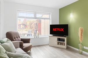 a living room with a tv and a couch at 3 bed home in Wollaton, Nottingham in Chilwell