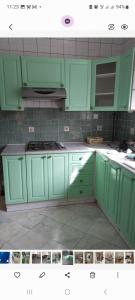 a kitchen with green cabinets and a stove at Demeure coup de cœur in LʼAgha