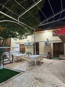 Un patio con mesas y sillas y un edificio. en Islam guest house, en Samarkand