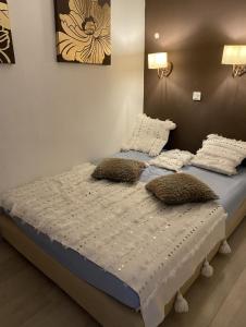 a bed with two pillows on it in a room at Alpe d'Huez 21 in LʼHuez