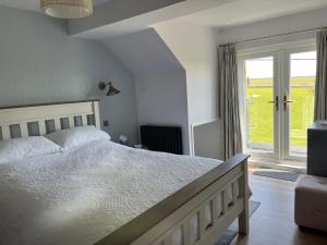 a bedroom with a bed and a large window at Woodlands Coastal Apartment in Southerndown +15 photos