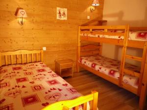 Un dormitorio con dos literas en una cabaña. en Le Chalet de La Pat, en Hauteluce