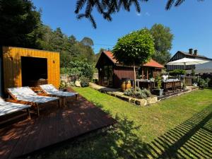 a backyard with a wooden deck with benches on it at Tiny House Všemily in Jetřichovice