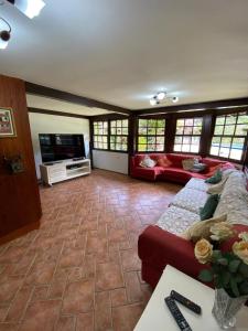 a living room with a couch and a tv at Vista da Montanha in Petrópolis +44 photos