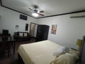 a bedroom with a bed and a ceiling fan at Hotel Garcias Suites, Linares in Linares +23 photos