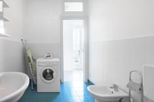 a white bathroom with a washing machine and a sink at Appartamento Gino in Cannero Riviera +14 photos
