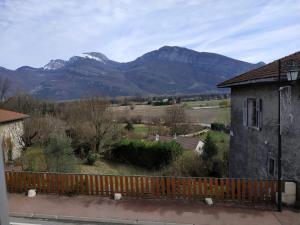 een uitzicht op de bergen vanuit een huis met een hek bij Maison Noyarey in Noyarey