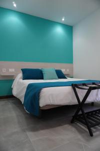 a bed in a room with a blue wall at Apartamento Sanin 1 in Lumbrales