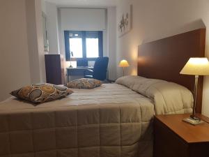 a bedroom with two beds and a table with a lamp at Bella ÁGUILAS - Excelente ubicación en Las Delicias, vistas al mar, Wifi y Parking gratis in Águilas