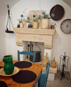 a dining room table with a fireplace with potted plants at Japp'ca Japp'ca in Castellaneta
