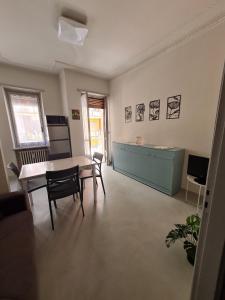 a living room with a table and chairs and a kitchen at casa vacanza il tulipano in Nichelino