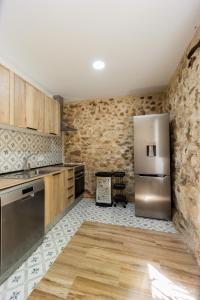 a kitchen with wooden cabinets and a stainless steel refrigerator at Las Golondrinas Experiencia Rural in Quesa +60 photos