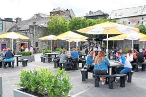 a group of people sitting at tables with umbrellas at City Centre Townhouse - just off Medieval Mile in Kilkenny