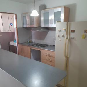 a kitchen with a white refrigerator and wooden cabinets at Apartamento al Este de Barquisimeto in Barquisimeto +2 photos