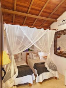 a bedroom with two beds with mosquito nets at Mini Casa com Jacuzzi e Piscina in Trancoso +34 photos