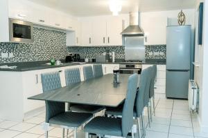a kitchen with a large wooden table and chairs at The Grace House Entire 4bed detached in Peterborough