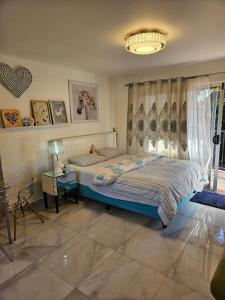 a bedroom with a bed and a chandelier at Cute comfortable, quiet studio 11 with Carpark in Auckland