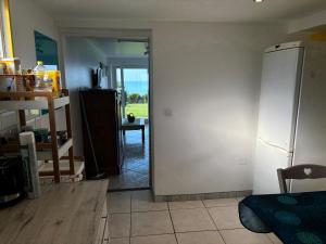 a kitchen with a door to a room with a refrigerator at THE LOK in Vassonville +24 photos