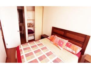a small bedroom with a bed with two pillows at Metroapart 3 in Santiago +4 photos