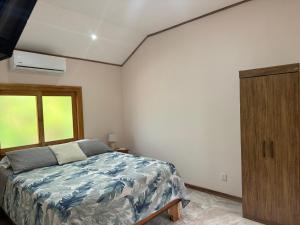 a bedroom with a bed and a wooden cabinet at Chilamate Room 2 in Tortuguero +13 photos