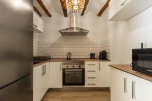 a kitchen with white cabinets and a stove and a microwave at Casa rural las golondrinas in Quesa
