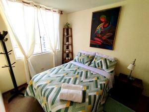 Un dormitorio con una cama y un cuadro en la pared. en Habitación con vista al mar, en Lima