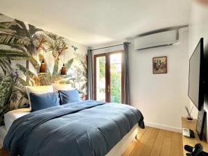 a bedroom with a bed with a blue comforter at Appartement avec Jacuzzi - Climatisation - Parking in Bordeaux
