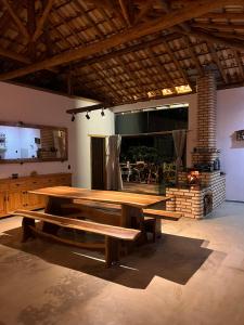 a large wooden table and benches in a room at Casa Descanso Acuruí in Itabirito